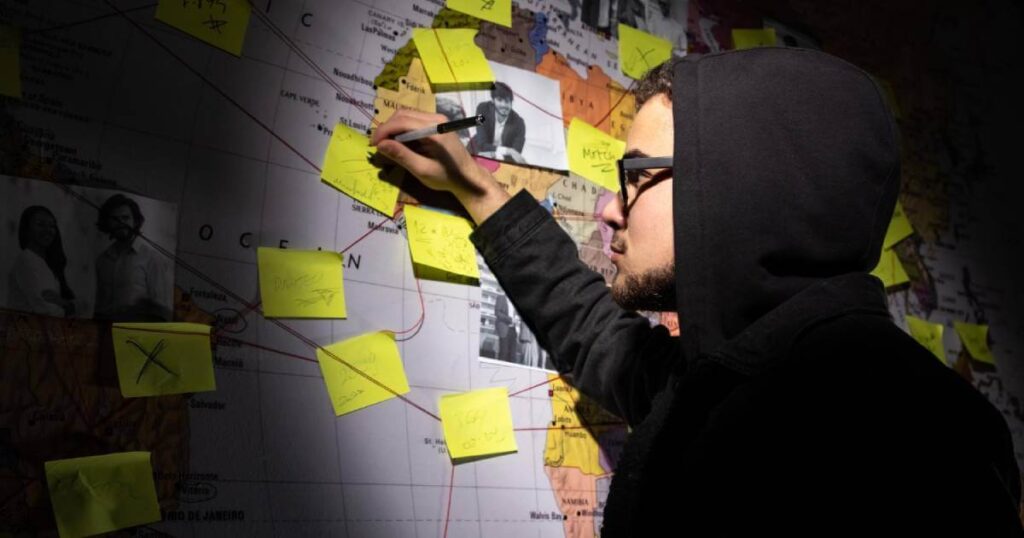 A dramatic, close-up shot of a detective's conspiracy board with red strings connecting various documents and photos, all leading to a central, circled number 23.