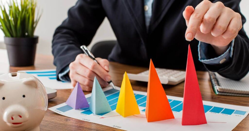 A person working diligently on a laptop and writing in a planner, showing the inspired action required to manifest real wealth.
